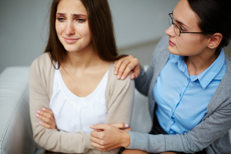 Psychologist supporting crying woman during session