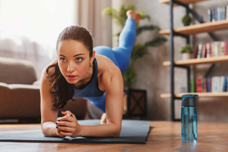 Fit young woman working out at home on mat