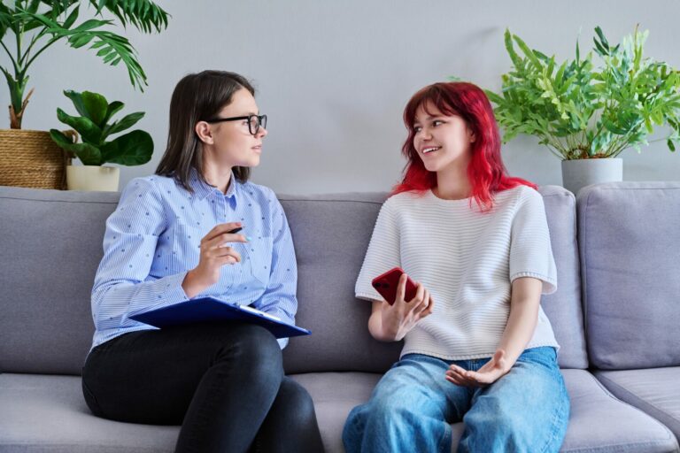 Psychologist counseling teenage female, individual therapy in doctors office. Professional cocellor helping teenager, girl with smartphone. Mental health, adolescence, psychology, psychiatry concept